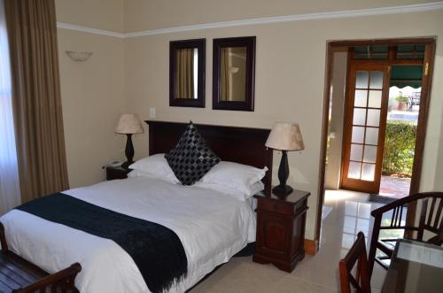 a bedroom with a bed and two lamps and a window at Lemoenkloof Boutique Hotel in Paarl