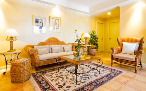 a living room with a couch and two chairs at Sophia Suites Residence Hotel in Cebu City