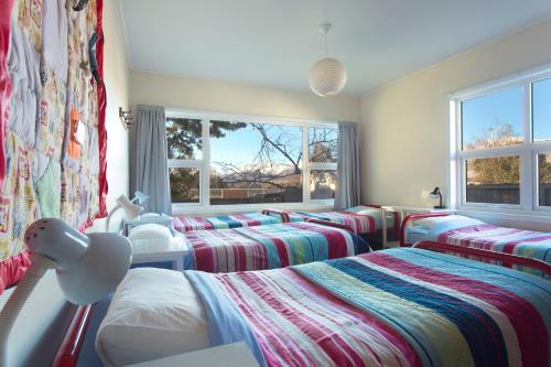 Tailor Made Tekapo Accommodation - Guesthouse & Hostel tesisinde bir odada yatak veya yataklar