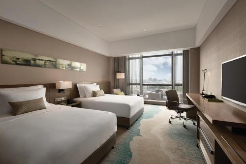 Postel nebo postele na pokoji v ubytování Wyndham JinJiang Hotel
