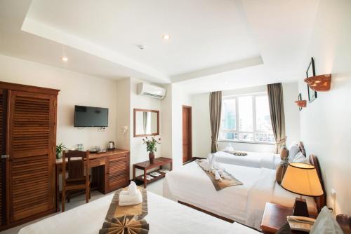 een hotelkamer met een bed en een bureau bij Relax Hotel in Phnom Penh