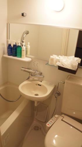 a bathroom with a white toilet and a sink at Hotel SUI Ginza Kyobashi by ABEST in Tokyo