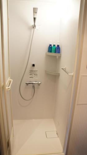 a bathroom with a shower with a hose at Hotel SUI Ginza Kyobashi by ABEST in Tokyo