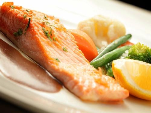a plate of food with fish and vegetables at Orussey One Hotel & Apartment in Phnom Penh