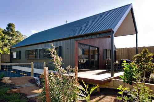 a small house with a black roof at Margaret River Bungalow-1-street - pet friendly in Margaret River Town