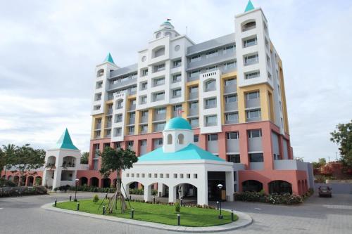 a large white building with a blue roof at Wonderla Resort in Kumbalgod