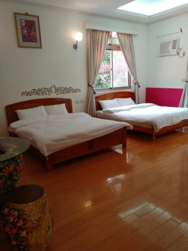 石碇區的住宿－三才靈芝民宿，一间卧室设有两张床和窗户。