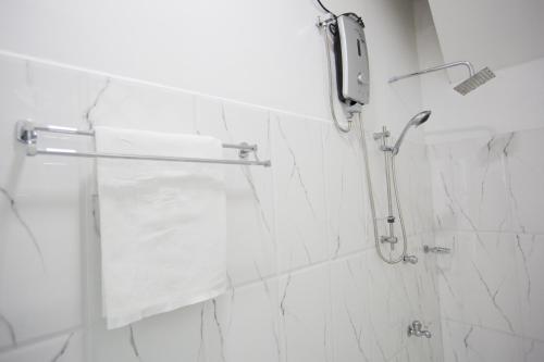 y baño con ducha y paredes de mármol blanco. en Freedom Apartment 1, en Galle