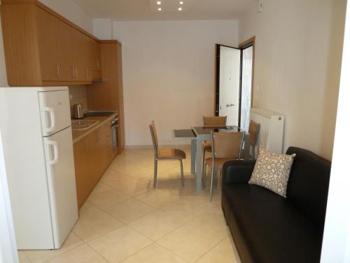 a kitchen with a couch and a table with chairs at Dimi Apartments in Metamorfosi