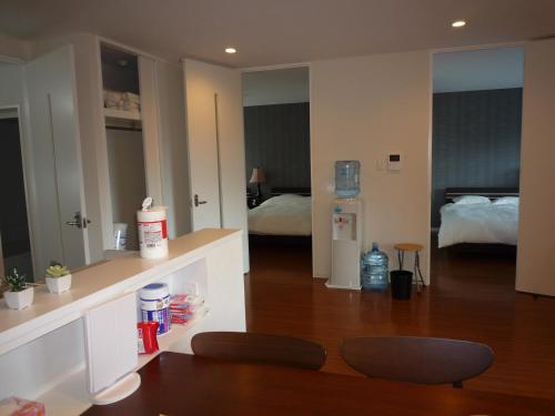 a living room with a room with a bed and a chair at MihaMac in Chatan