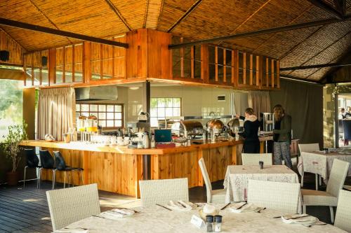 a restaurant with a counter with tables and chairs at Surval Boutique Olive Estate in Oudtshoorn