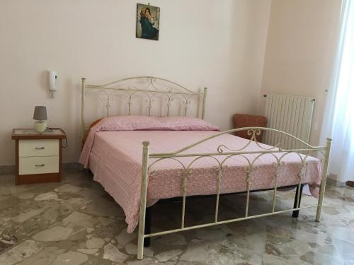 マティーノにあるCasa nel Salento da Graceのベッドルーム1室(ピンクの毛布付きの金属製ベッド1台付)