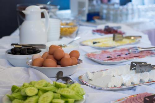 a table topped with plates of food and eggs and vegetables at Guest House Granat in Sunny Beach