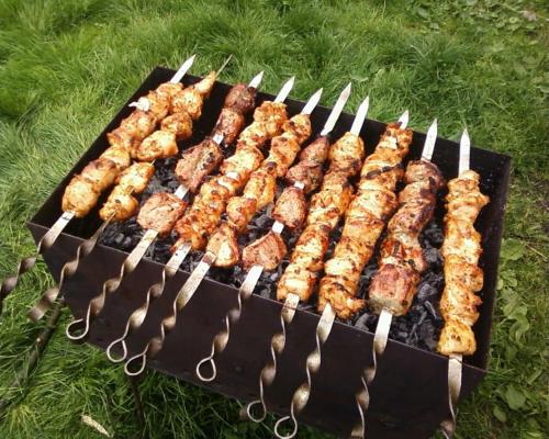 a grill with several skewers of food on it at Europa Hotel-Kutaisi in Kutaisi
