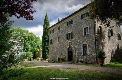 a large stone building with a tree in front of it at Appartamenti Lais in Sipicciano in Sipicciano