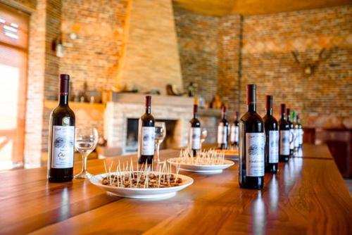 una fila de botellas de vino sentadas en una mesa de madera en Europa Hotel-Kutaisi en Kutaisi