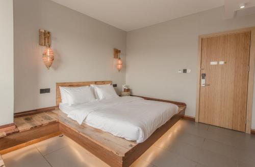 a bedroom with a large bed with a wooden frame at Zen Tea House Seven Stars Park in Guilin