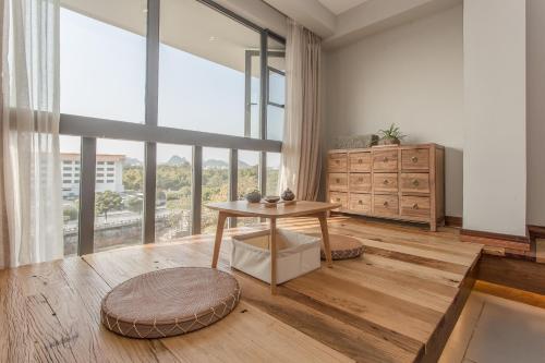 a living room with a table and a large window at Zen Tea House Seven Stars Park in Guilin