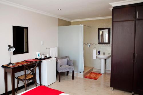a bathroom with a desk and a sink in a room at Aloes No.21 in Amanzimtoti