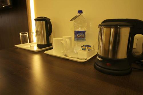 a coffee maker and a bottle of water on a counter at Hotel Forest Avenue - Best Luxury Hotel in Dehradun in Dehradun