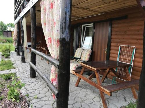 a patio with a table and chairs on a house at Sadyba u Gansa in Svityazʼ