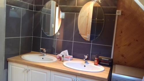 a bathroom with two sinks and two mirrors at Calme et nature in Saint-Gravé