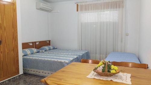 a room with two beds and a table with flowers on it at Apartamentos Berlin in San Pedro del Pinatar