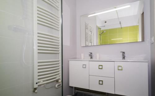 a white bathroom with a sink and a mirror at Le Courtoisville Apartment in Saint Malo