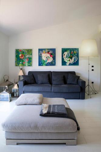a living room with a blue couch and paintings on the wall at Agriturismo La Casa Di Rodo in Quarrata