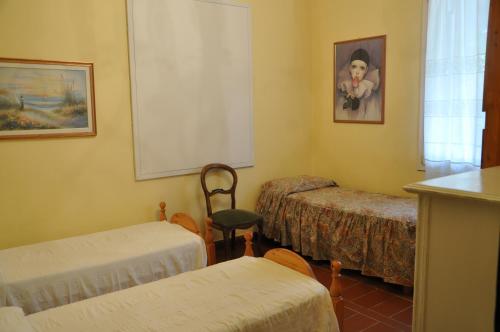 マッサローザにあるCasa Vacanze Graziaのベッド3台、椅子、窓が備わる客室です。