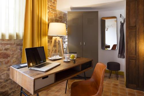 a desk with a laptop computer on top of it at Contact Hôtels Le Savigny & Spa in Blacé