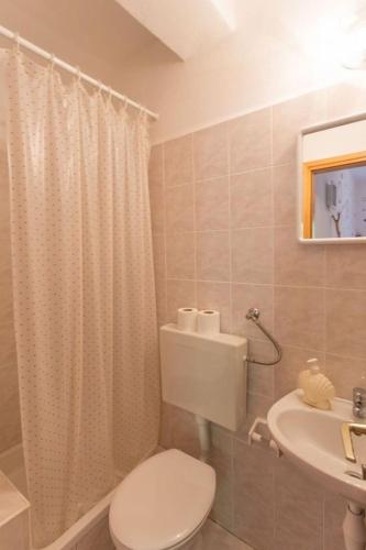 a bathroom with a toilet and a sink at Robinson Erina in Zarače