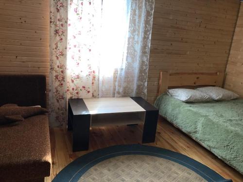 a room with a bed and a table and a window at Sadyba u Gansa in Svityazʼ
