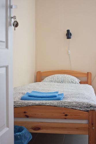 a bed with a blue pair of tongs on it at Kihnu Sadama Öömaja Guesthouse in Lemsi