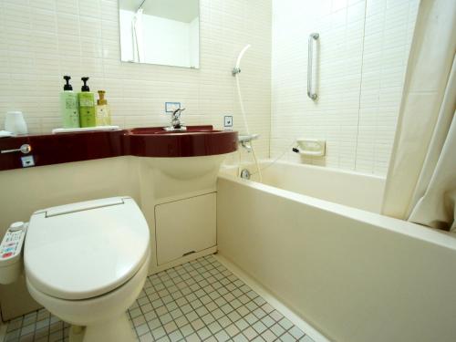 a bathroom with a toilet and a tub and a sink at Hotel Trend Saijo in Saijo