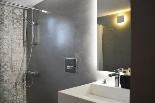 アテネにあるLikavittos Apartmentsのバスルーム(シンク、鏡付きシャワー付)