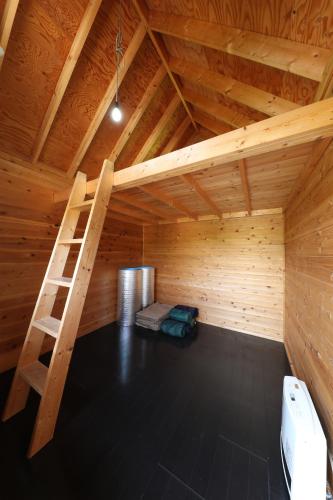 a room with a ladder in a wooden attic at Asian Camp Resort TAPA in Minakami