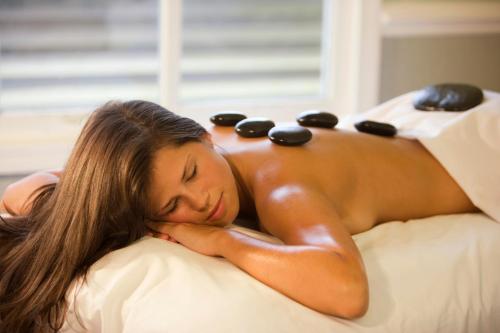 a woman laying on a bed with a massage at Hotel Alle Alpi in Moena