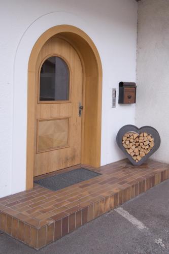 a wooden door with a heart on the side of a building at Appartements Lilly Rose in Zell am Ziller
