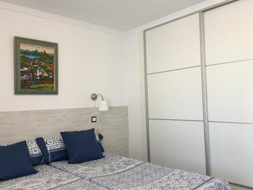 - une chambre avec un lit et des oreillers bleus dans l'établissement Casa del Sol, à Fuengirola