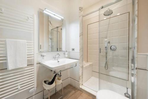 bagno bianco con lavandino e doccia di Appartamenti Fortezza Da Basso a Firenze