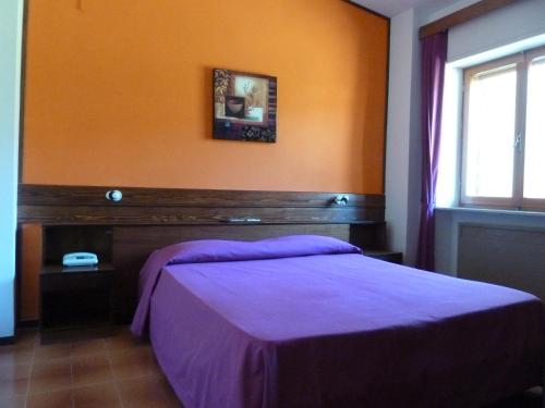 a bedroom with a bed and a window at Hotel Caldora in Rocca di Mezzo