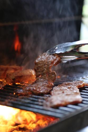 a steak being grilled on a grill with a spatula at Asian Camp Resort TAPA in Minakami