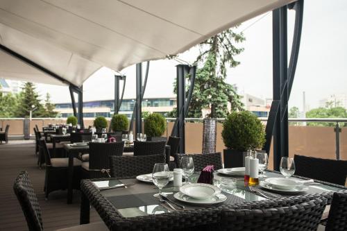 a restaurant with tables and chairs on a patio at Hemus Hotel Sofia in Sofia