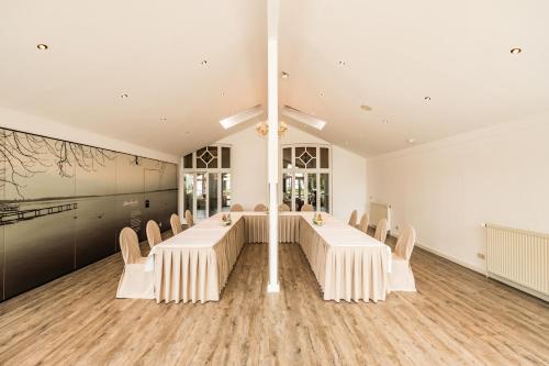a large room with a long table and chairs at Das 53°Hotel in Bad Zwischenahn