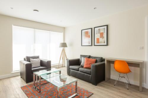 a living room with a couch and a table at House of Fisher- Solstice House Apartments in Farnborough