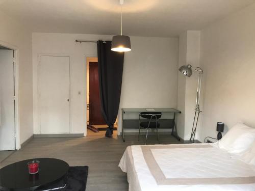 une chambre avec un lit, une table et un bureau dans l'établissement Pascal Paoli, à Corte