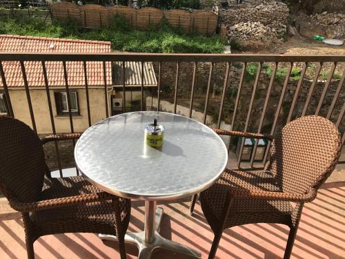 une table et deux chaises assises sur une terrasse dans l'établissement Pascal Paoli, à Corte