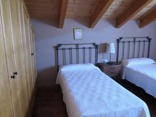 a bedroom with two beds and a wooden ceiling at Casa Marcial in Chía