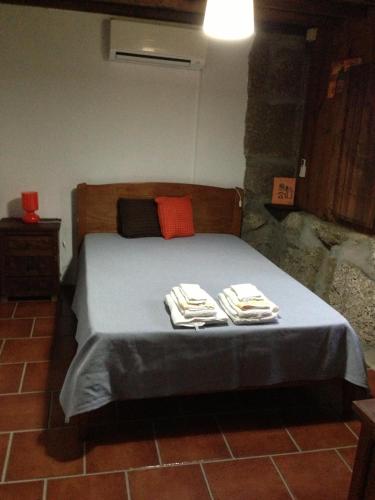 a bedroom with a bed with two towels on it at Havan House in Amarante